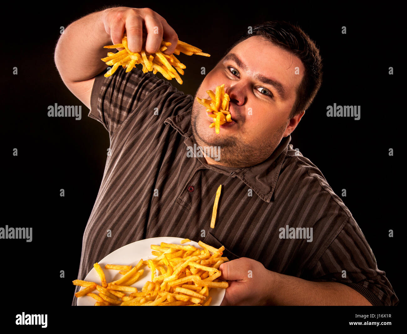 Dicker Mann essen Fastfood Pommes frites für übergewichtige. Stockfoto