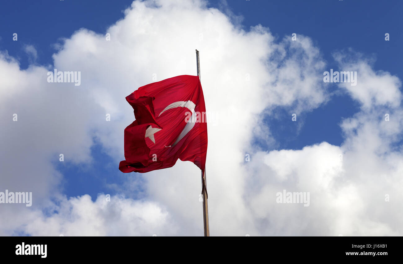 Türkische Flagge am Fahnenmast am sonnigen Tag im Wind wehende Stockfoto