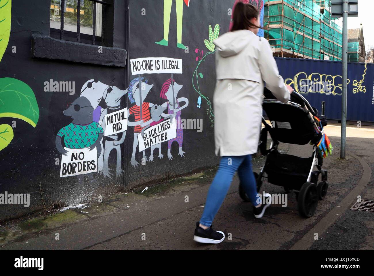 Eine Gesamtansicht der Frau zu Fuß vorbei an Graffiti. Stockfoto