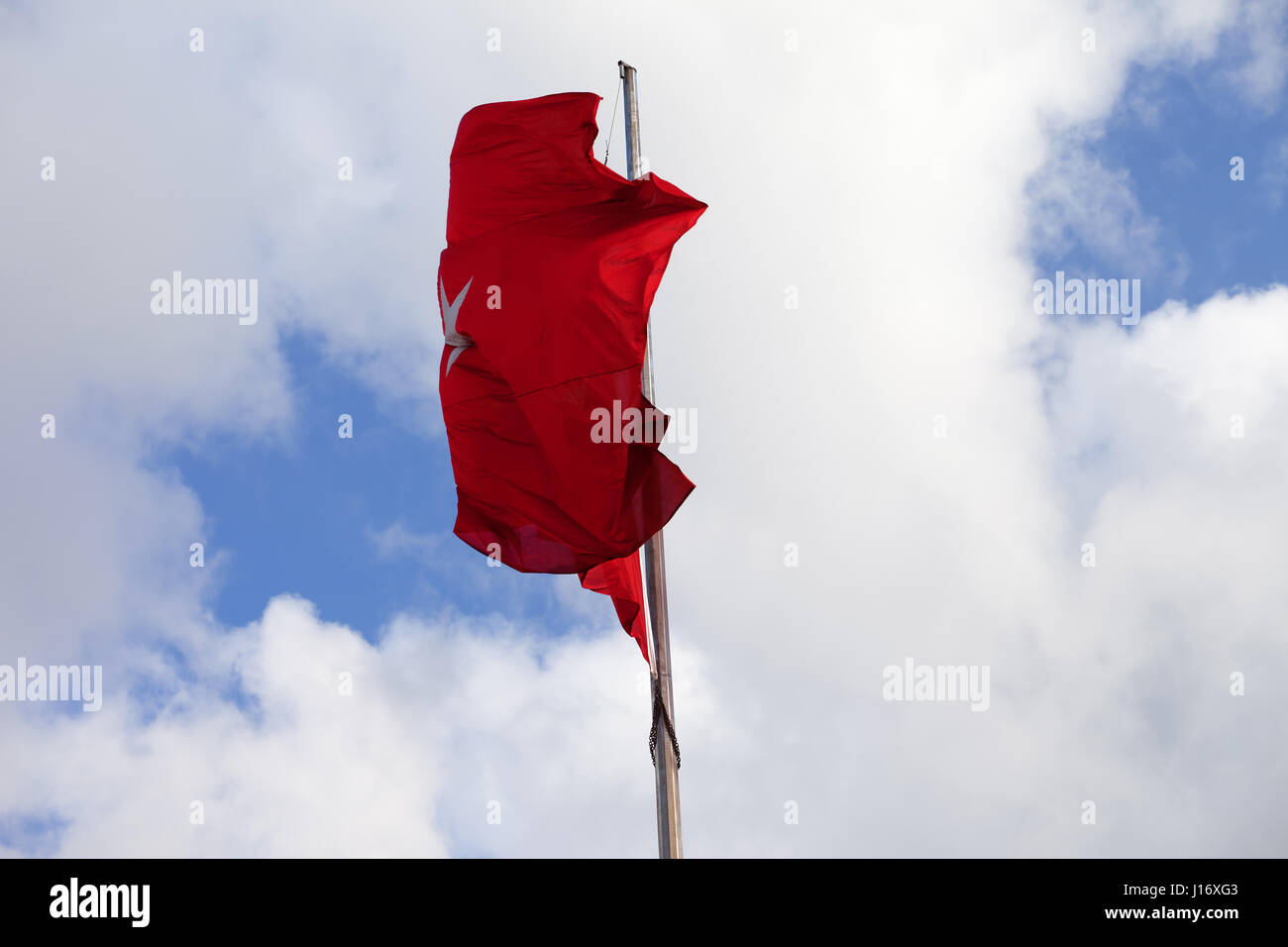 Türkische Flagge am Fahnenmast wehenden Wind am Himmel mit Wolken Stockfoto