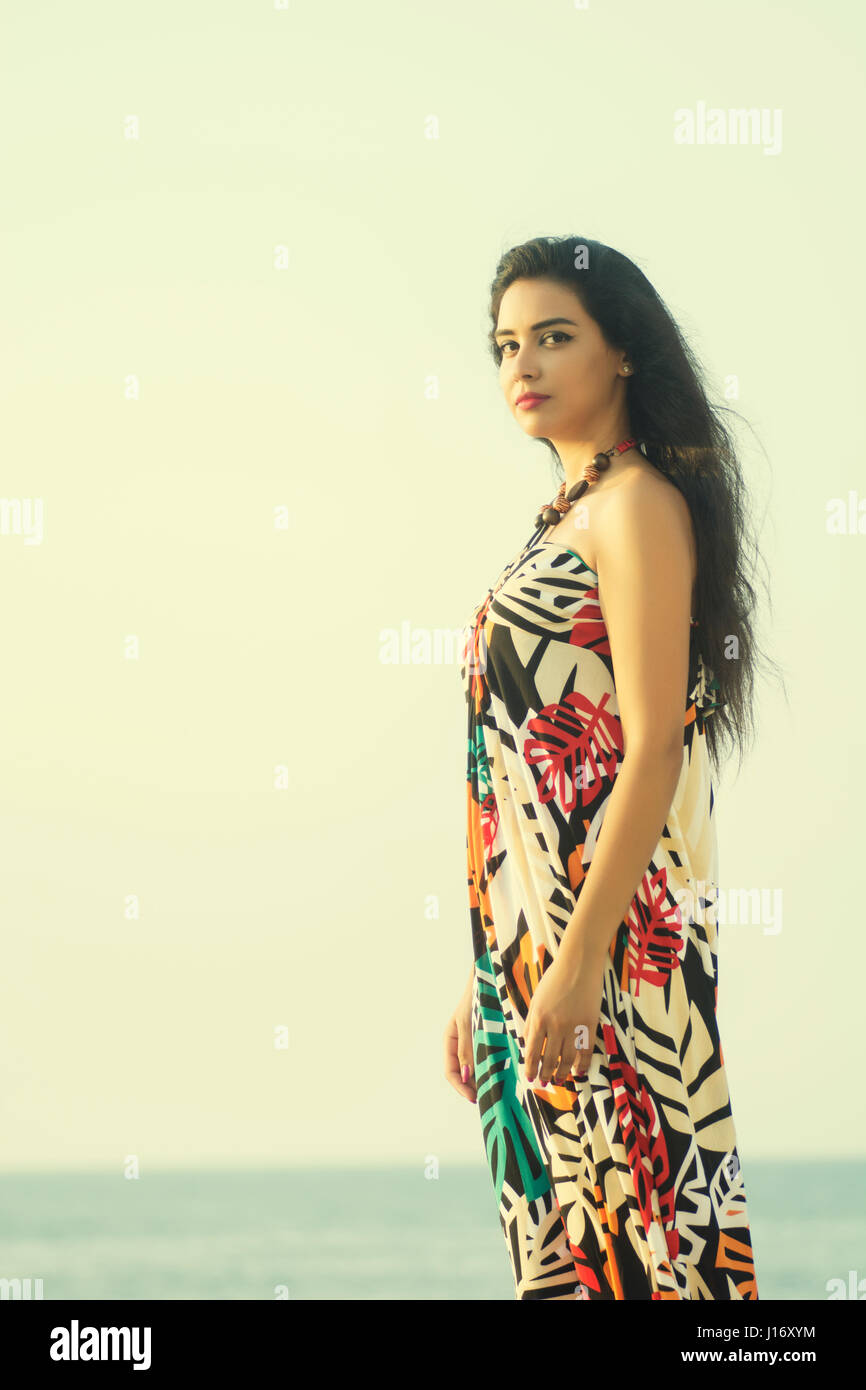 Schöne junge Frau trägt ein Sommerkleid stehen am Strand Stockfoto