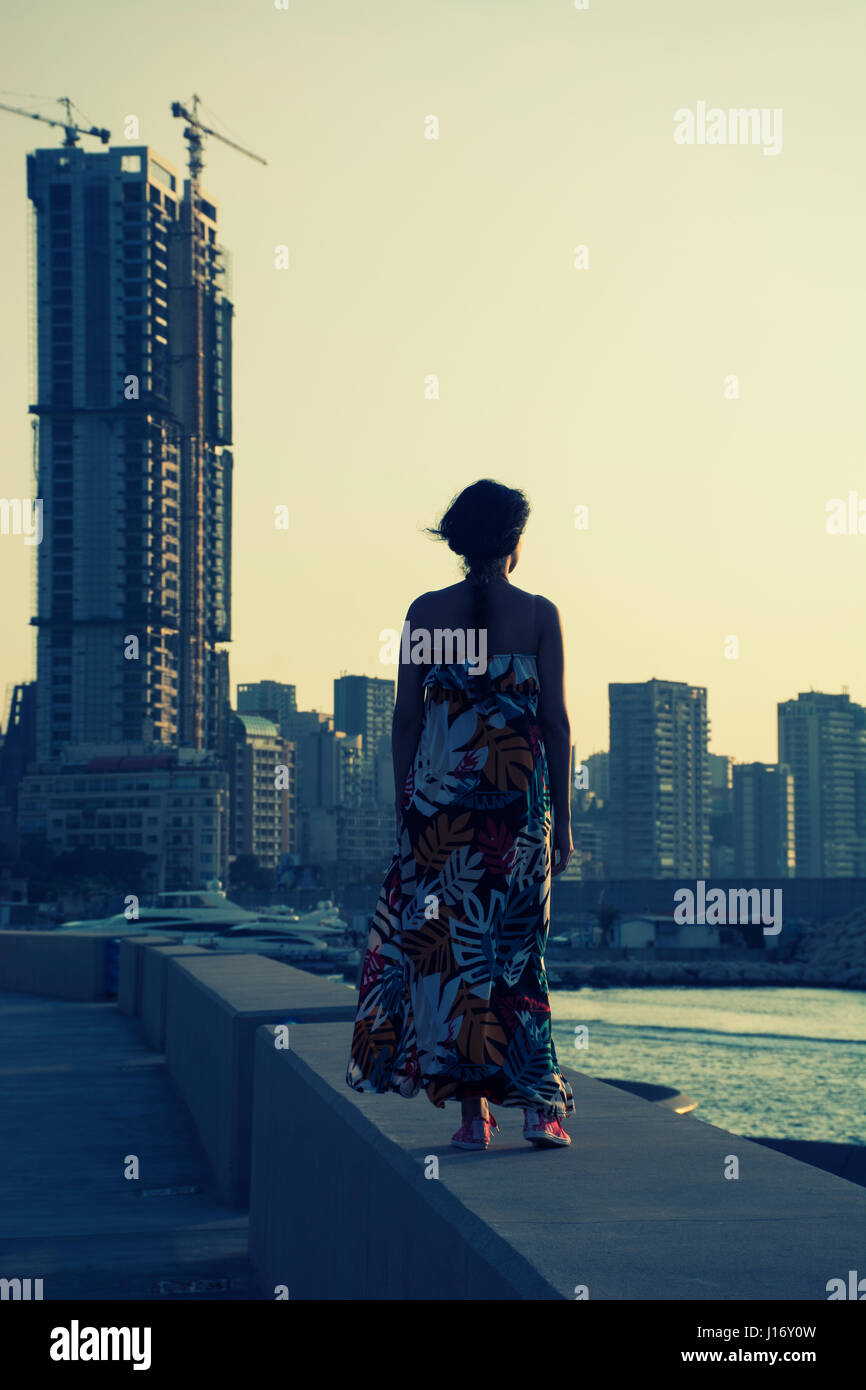 Rückansicht einer Frau mit einem Sommerkleid stehend gegen die skyline Stockfoto