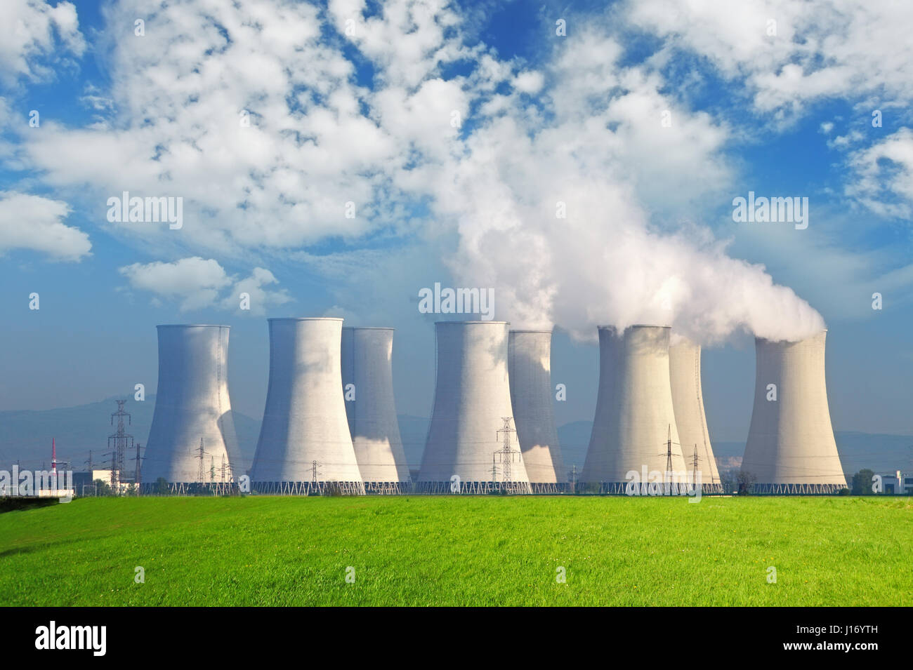 Kernkraftwerk mit gelben Feld und große blaue Wolken Stockfoto