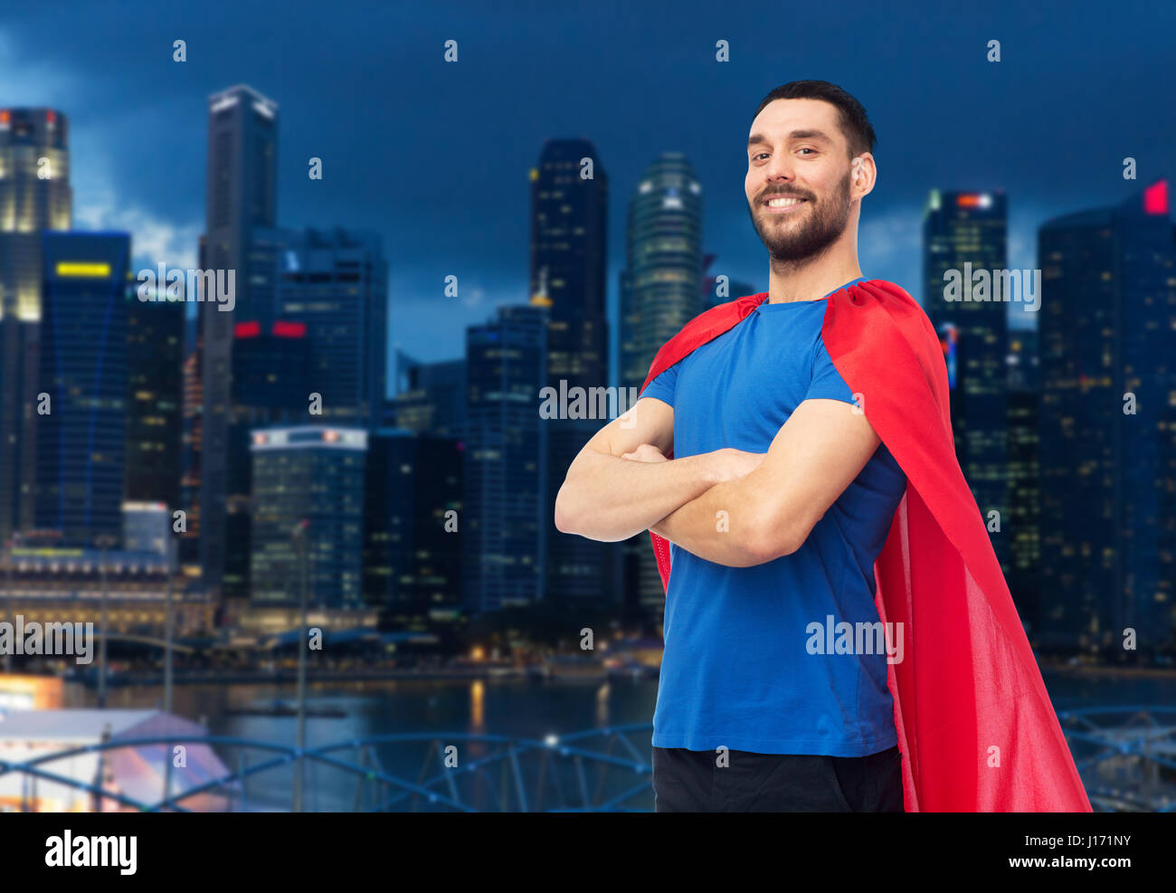 glücklicher Mann im roten Superhelden Cape über Nacht Stadt Stockfoto
