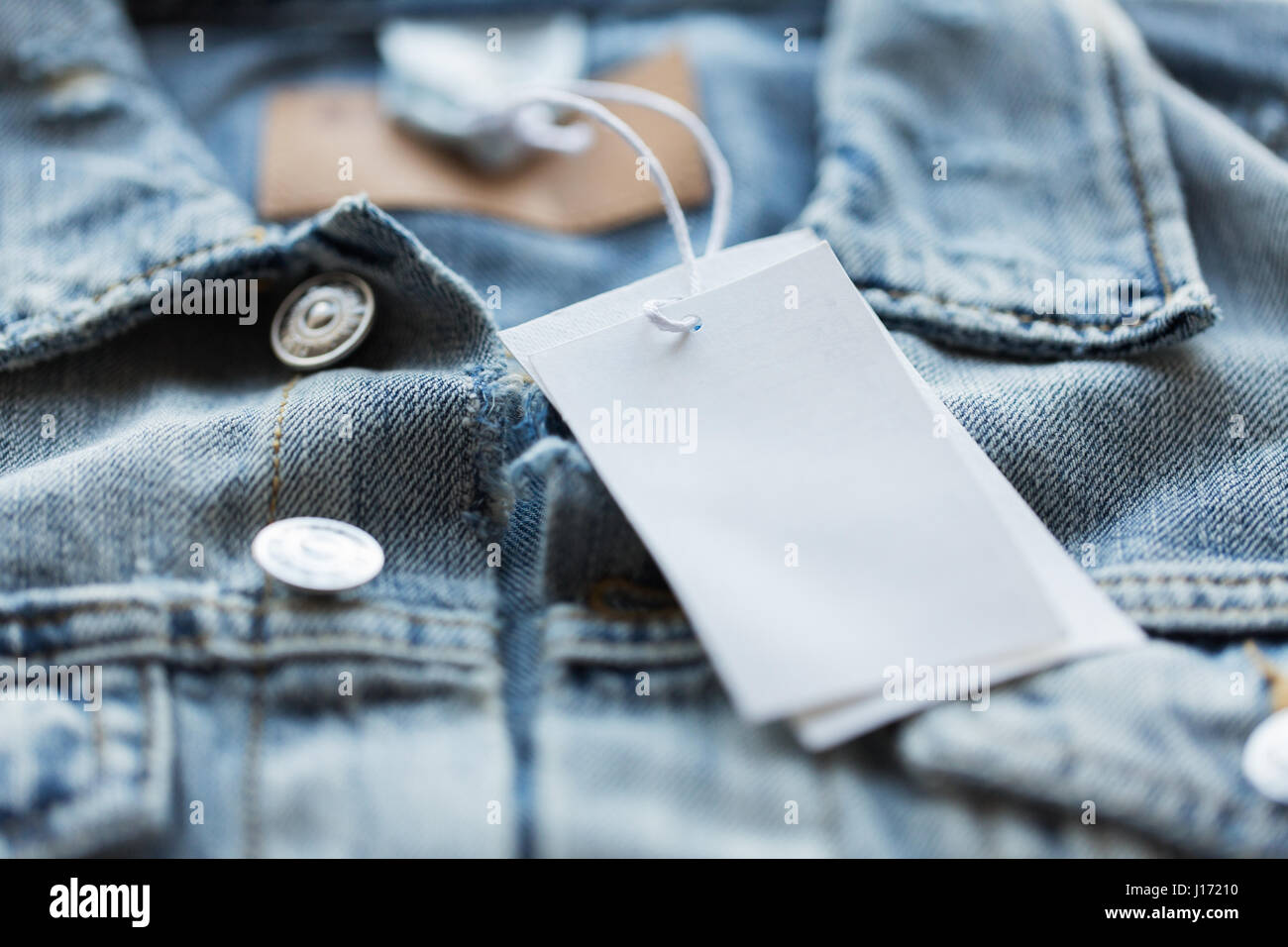 Nahaufnahme von Jeansjacke mit weißen Preisschild Stockfoto