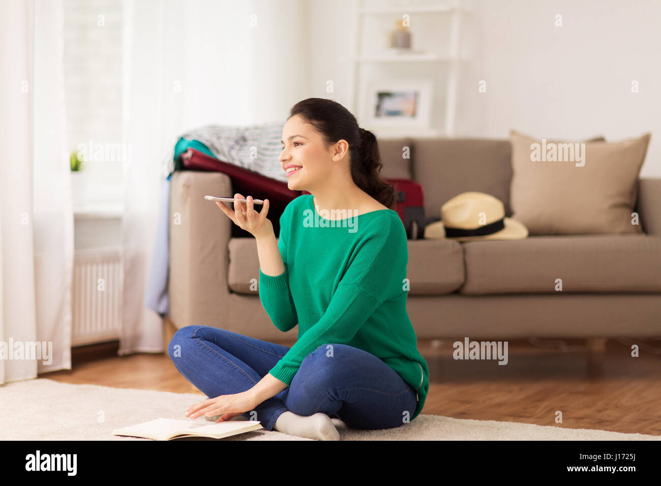 Frau mit Smartphone und Reise-Karte zu Hause Stockfoto