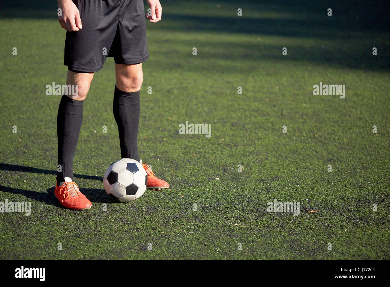 Fußballspieler mit Ball auf Fußballplatz spielen Stockfoto