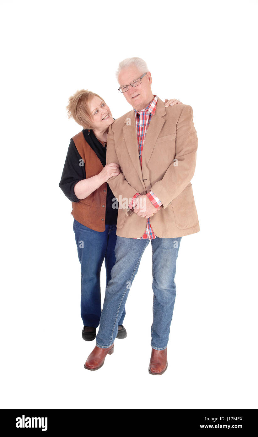 Eine schöne älteres Ehepaar im lässigen Tuch stehen, einander umarmen, isoliert lächelnd, weißen Hintergrund. Stockfoto