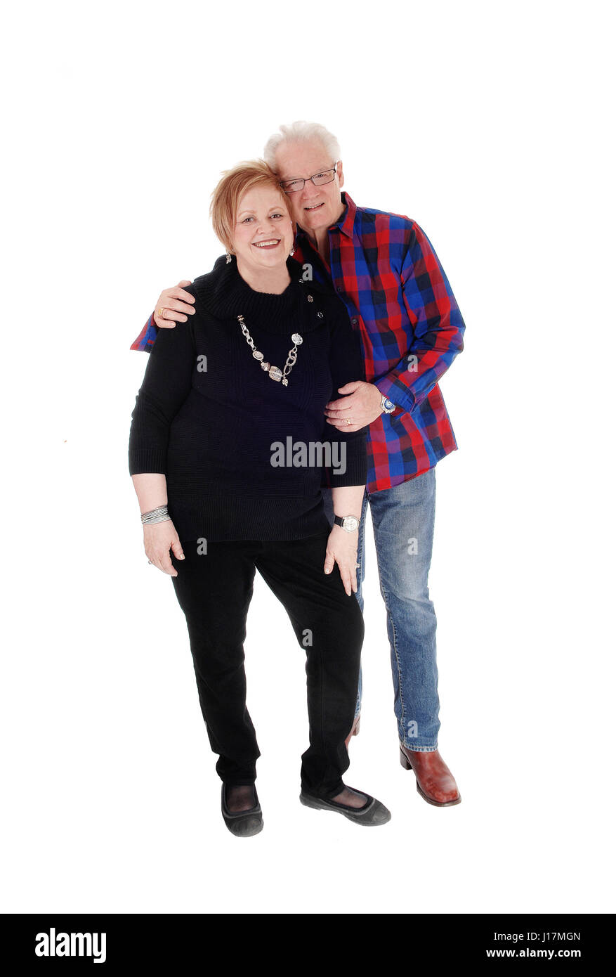 Eine schöne ältere paar stehen in lässigen Tuch, hält der Mann seine Frau, Lächeln, für weißen Hintergrund isoliert. Stockfoto