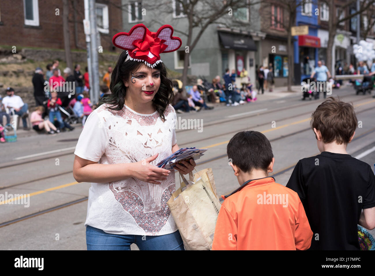 Frau in Ostern Kostüm verteilt Geschenke an die Kinder entlang der Queen Street East Strände Easter Parade 2017. Stockfoto