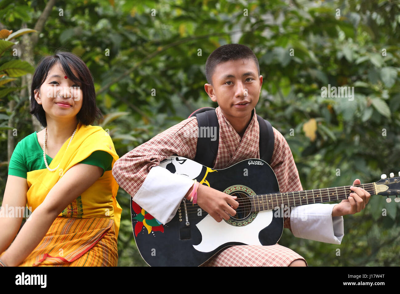 Bhutan junge hantierte, Gitarre und Bodo Mädchen in traditioneller Tracht. Nganglam, Bhutan Stockfoto