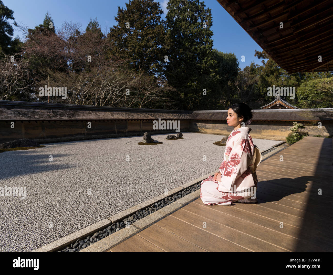 Junge Japanerin Kimono kniet neben den Steingarten an Ryōan-Ji, Kyoto. Eines der schönsten Beispiele für einen Verleih-Niwa Steingarten. Zen meditatio Stockfoto