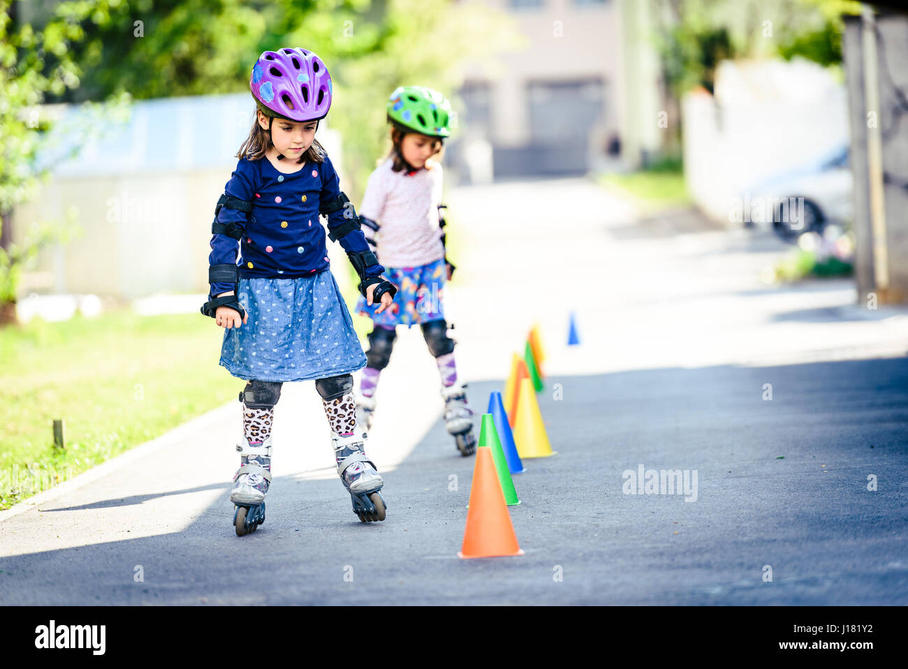Kinder lernen, Rollschuh auf der Straße mit Zapfen. Zwillinge sind
