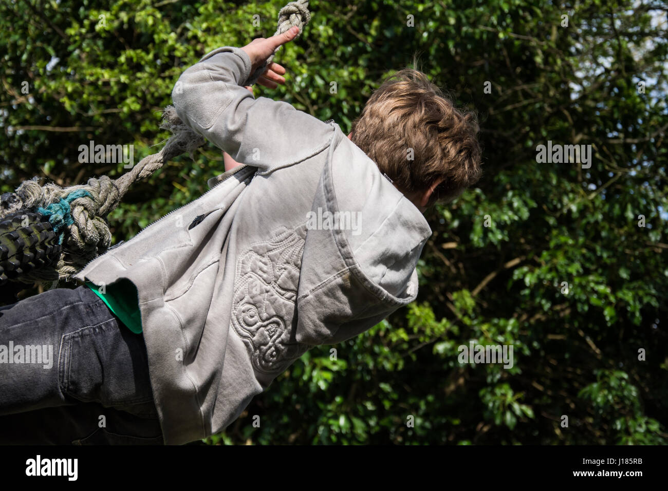 Junge spielt auf Seil schwingen, UK Stockfoto