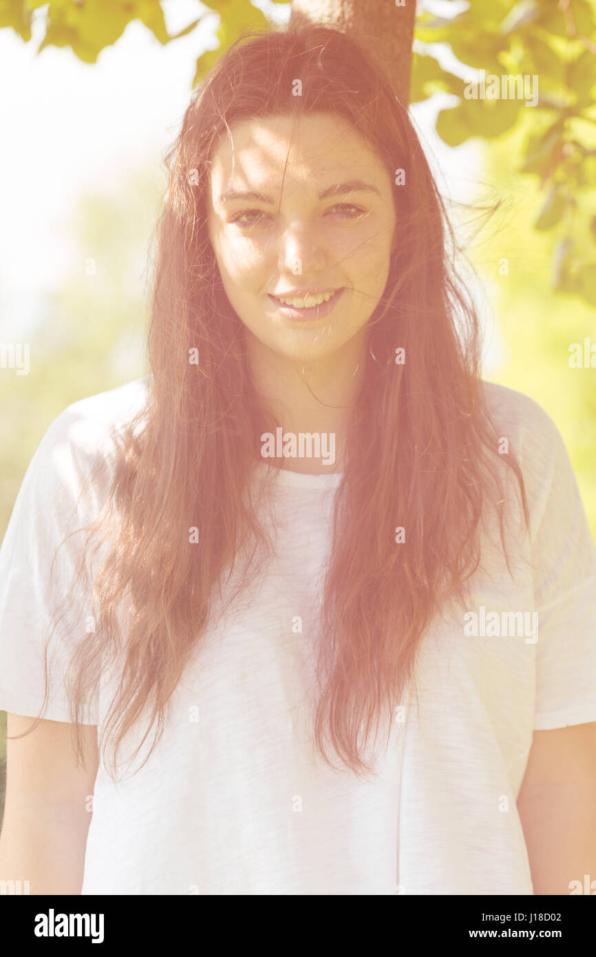 Porträt der jungen Frau im sonnigen Garten lächeln Stockfoto