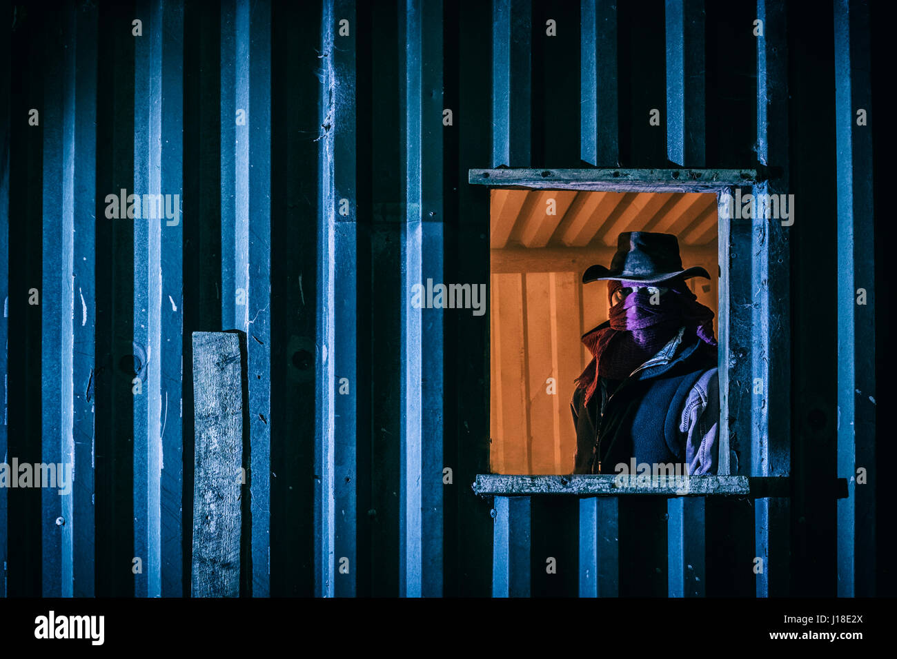 Maskierter Mann in das Fenster von einem Nebengebäude. Stockfoto