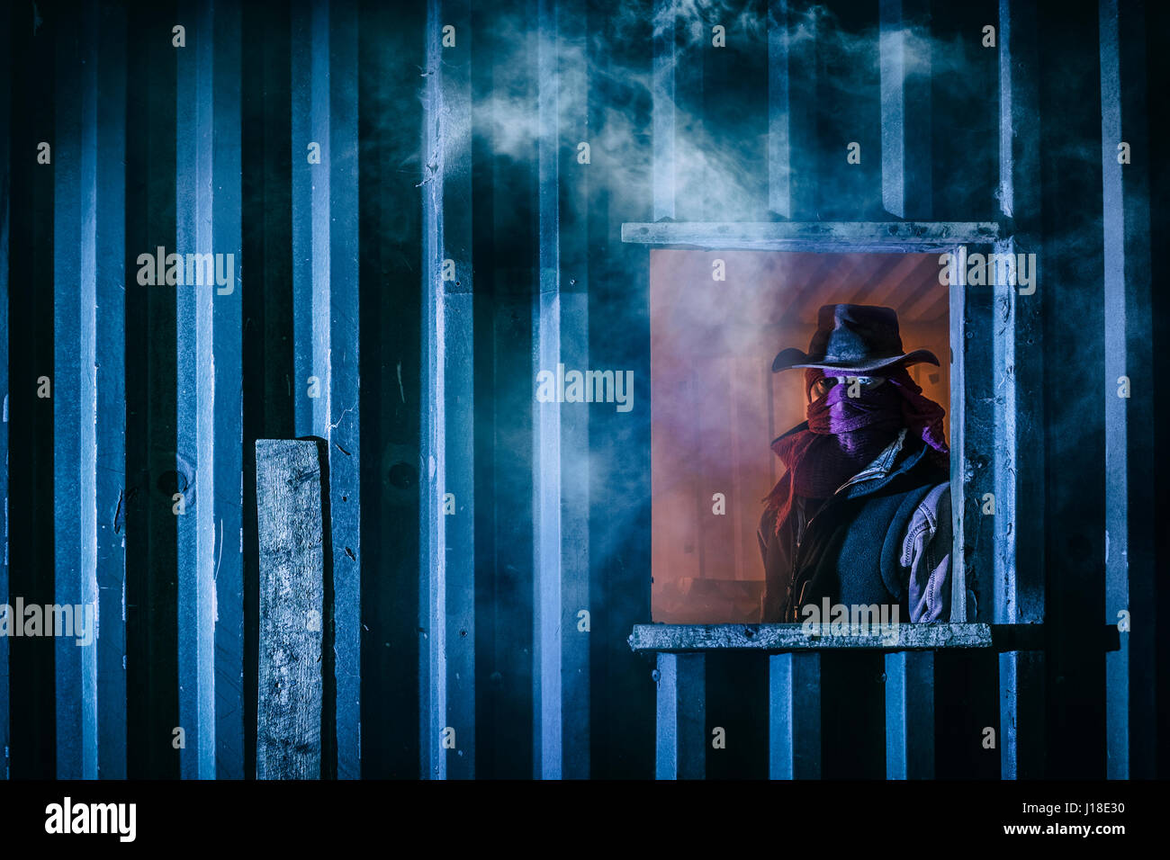 Maskierter Mann in das Fenster von einem Nebengebäude. Stockfoto