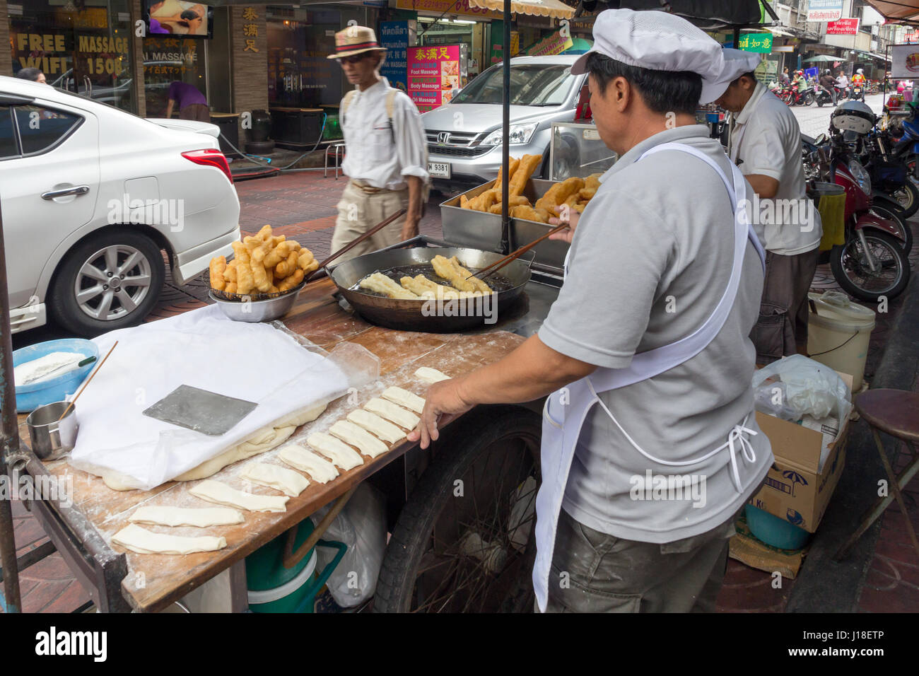 Man braten Churros auf einem Street Food Warenkorb in Chinatown, Bangkok, Thailand Stockfoto