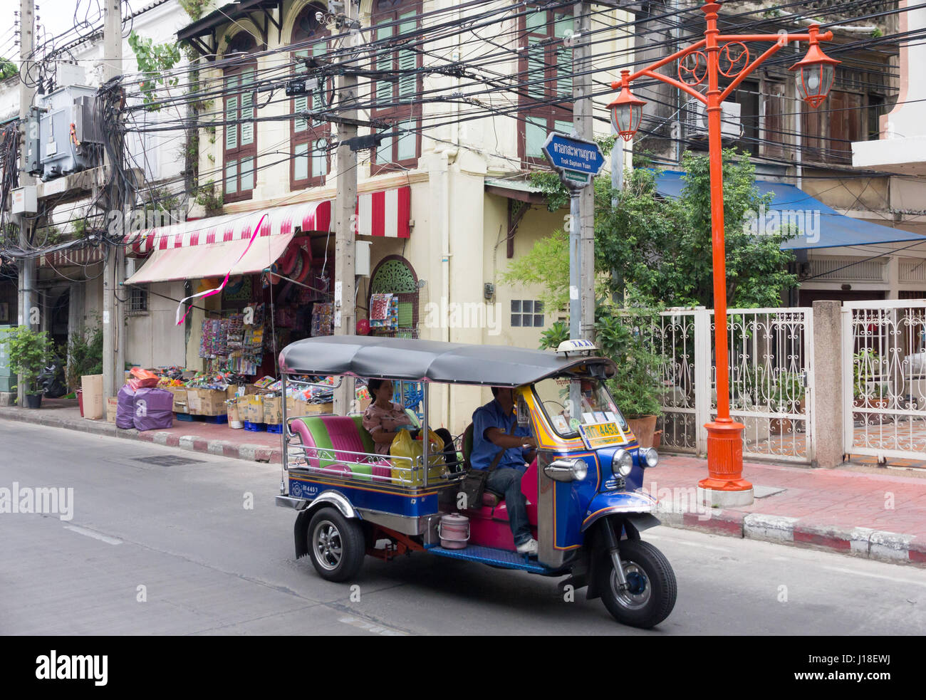 Ein Tuk-Tuk mit Passagier macht es Weg entlang einer Straße in Chinatown, Bangkok, Thailand Stockfoto