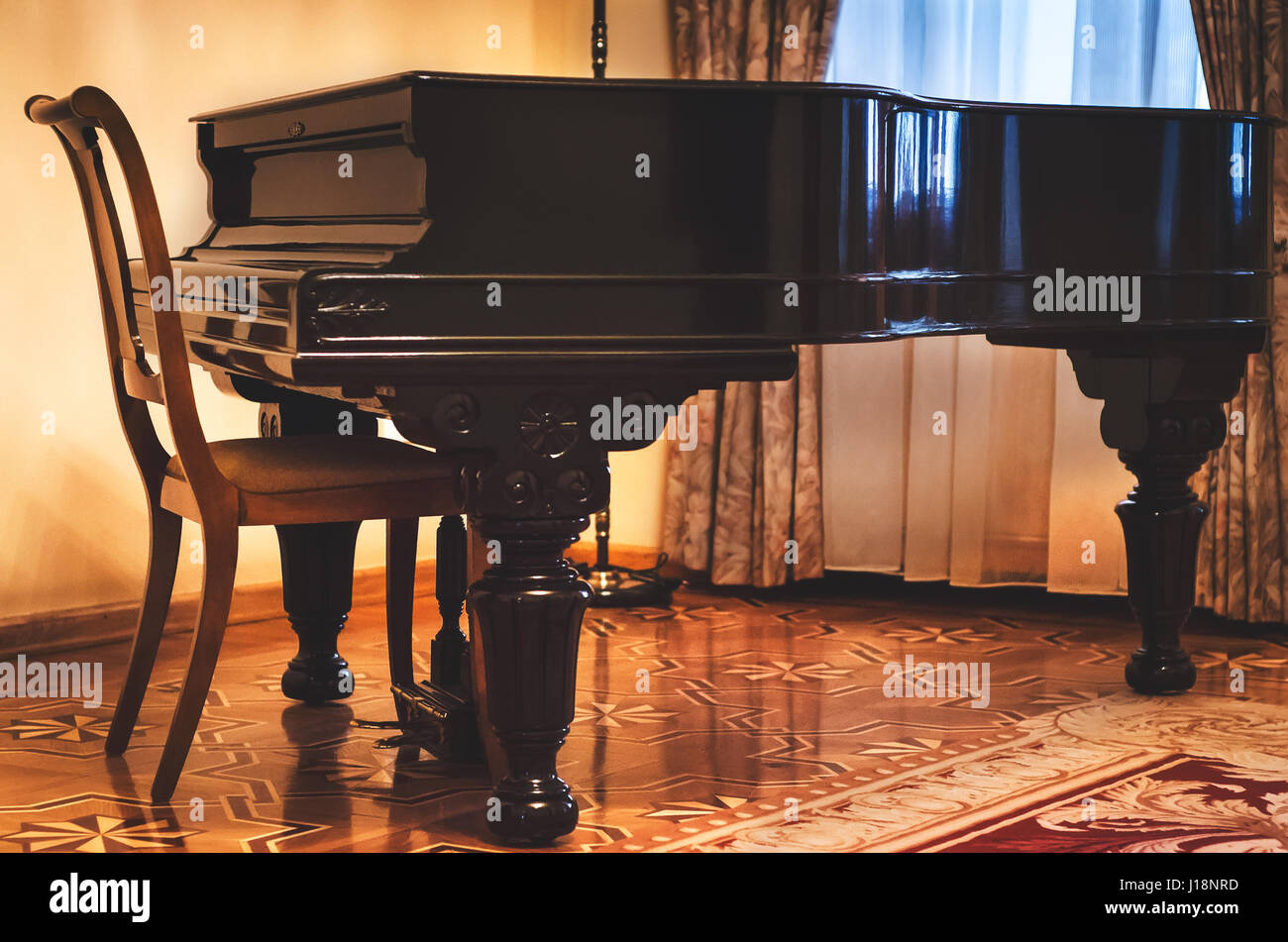 Einen klassischen geschlossenen Piano und Retro-Holzstuhl Marmor Boden Innenraum des klassischen Wohnzimmer Stockfoto