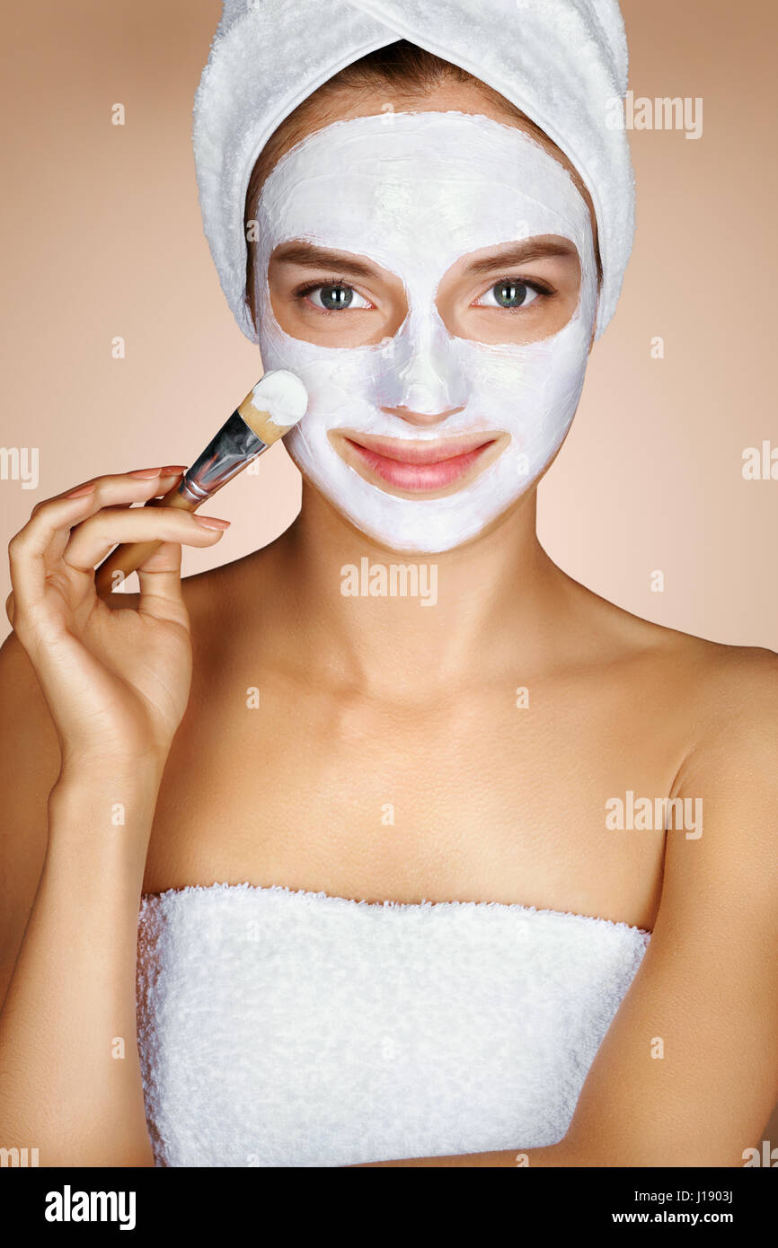 Junge Frau feuchtigkeitsspendende Gesichtsmaske anwenden. Foto von hübsche Frau erhält die Spa-Behandlungen. Schönheit & Skin care Konzept Stockfoto