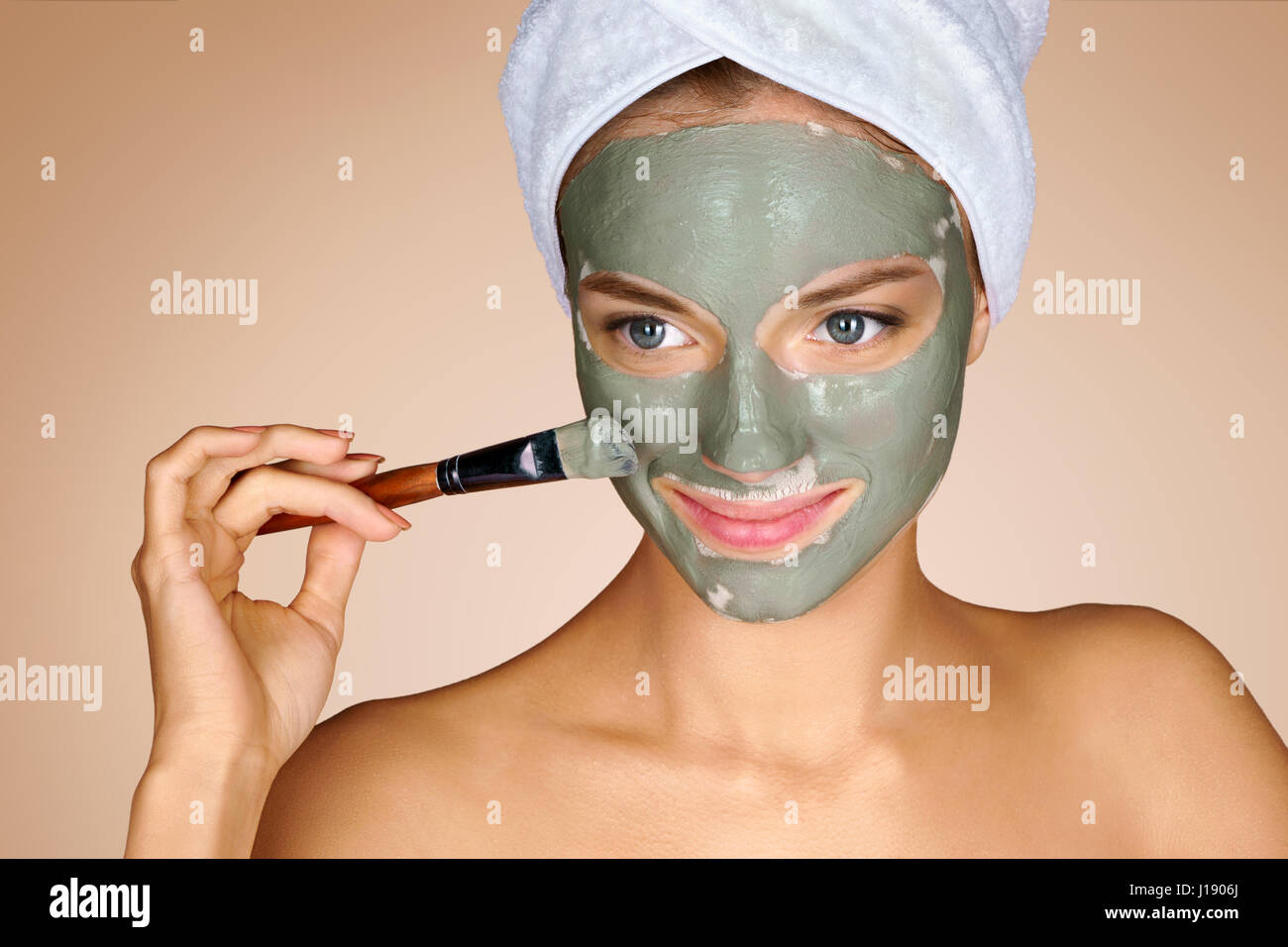Frau mit einer Gesichtsmaske. Foto von attraktiven jungen Frau, die Spa-Behandlungen erhalten. Pflege selbst Stockfoto