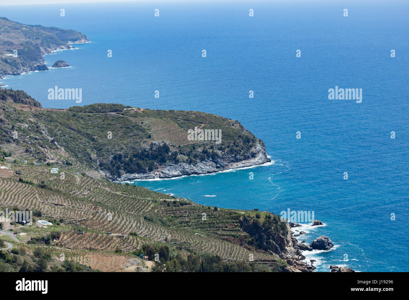 Horizontalen Schuss der mediterranen Seenlandschaft mit Hügeln von immergrünen Pflanzen und Bananenplantagen Abstieg zum Meer am sonnigen Tag erschossen Stockfoto