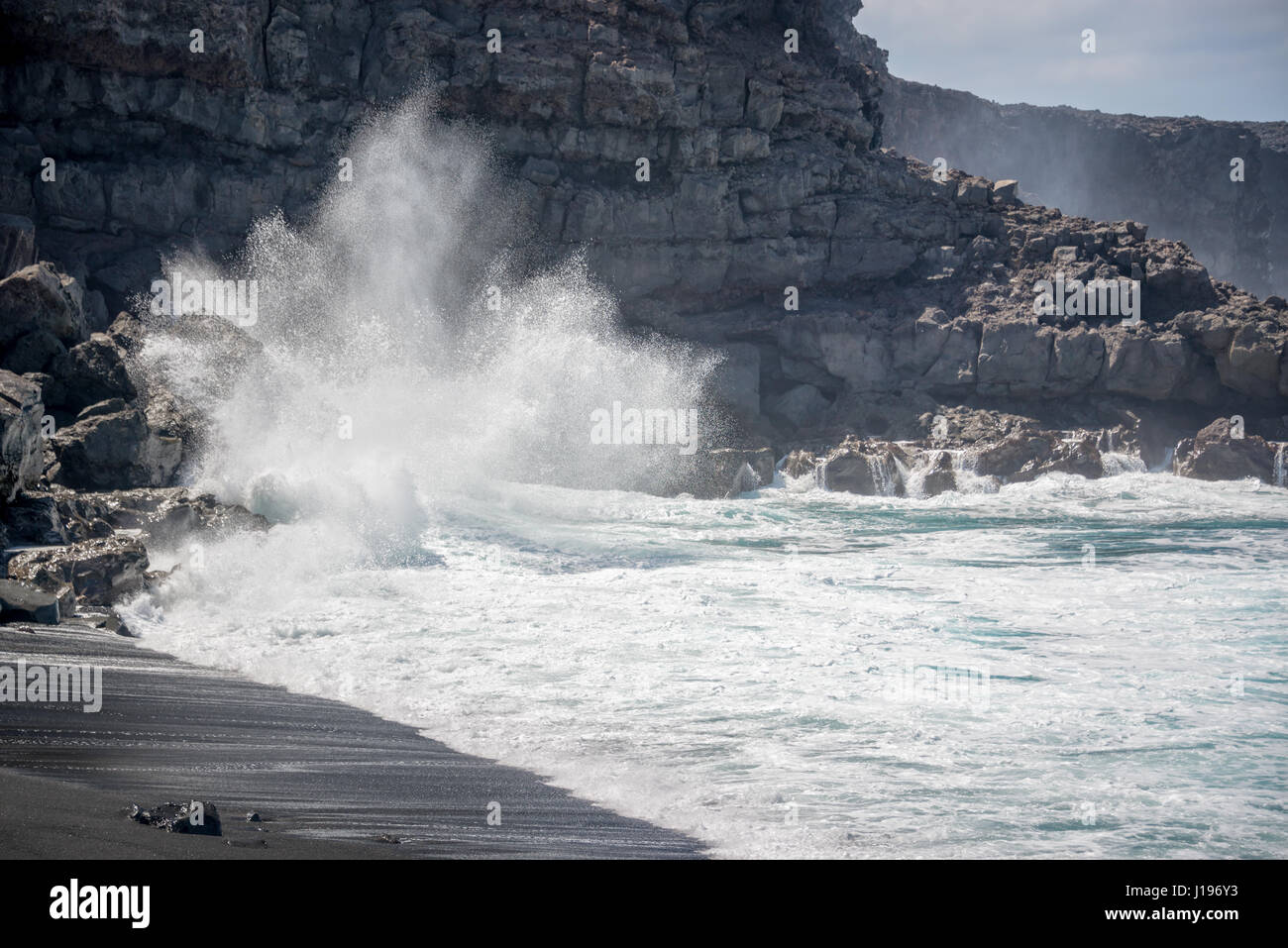 Riesige Welle stürzt auf den Felsen am Playa del Paso, einem schwarzen Sandstrand in Lanzarote, Kanarische Inseln, Spanien Stockfoto