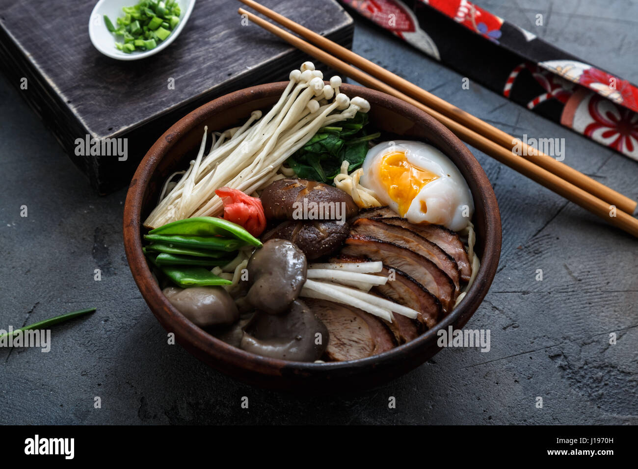 Schüssel Ramen-Nudeln mit Ei, Enoki, Shiitake-Pilze, Ente und Zwiebeln Stockfoto