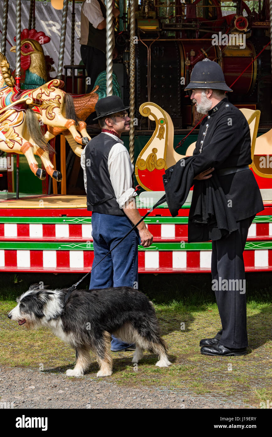 Karussell operator und Polizist (mit Hund) in historischen Kostümen am Blists Hill, in der Nähe der viktorianischen Stadt Madeley, Shropshire, England, UK. Stockfoto