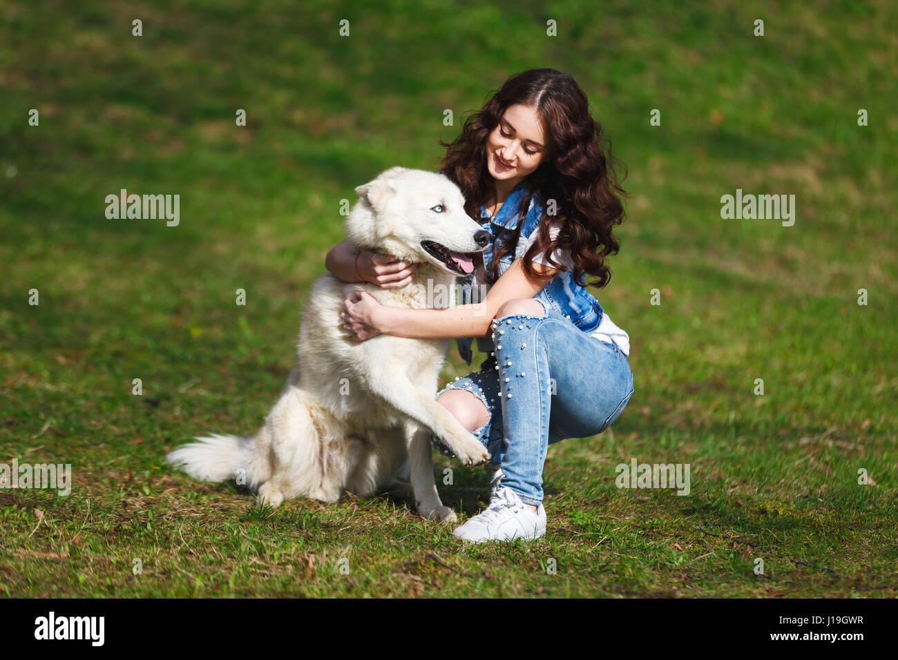 Teenager-Mädchen ist in einem Park zwei husky Hunde umarmt. Stockfoto