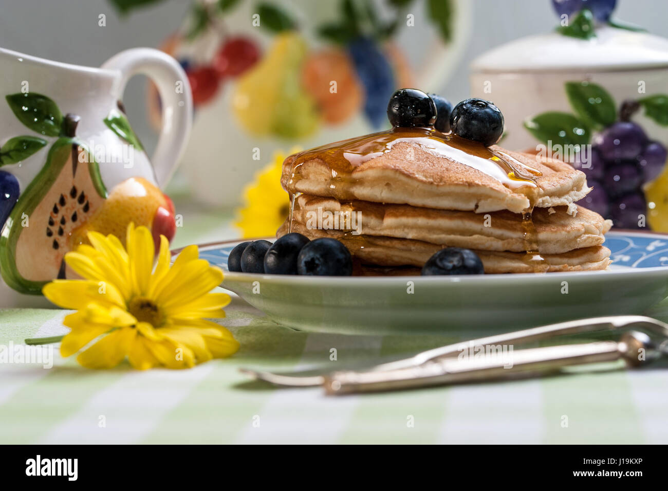 Frühstück Landschaft: leckere Pfannkuchen mit Heidelbeeren mit buntem Obst Thema Tee-Set. Stockfoto