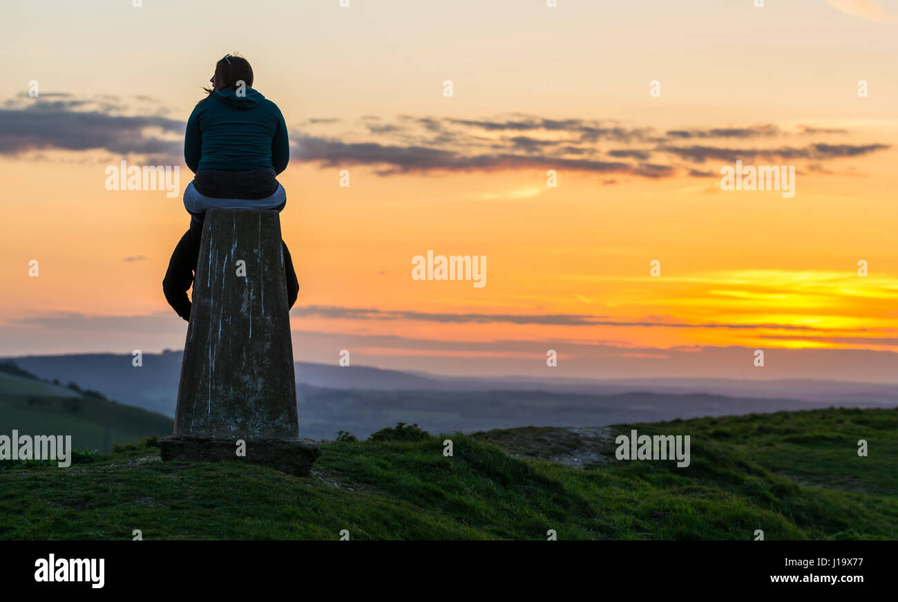 Paar beim Denkmal auf einem Hügel mit Blick auf die Landschaft bei Sonnenuntergang, im Süden auf und ab Hügel im Süden von England, UK. Stockfoto