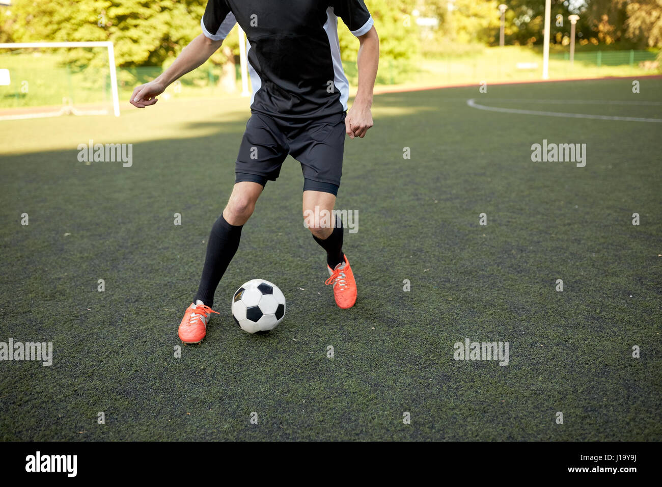 Fußballspieler mit Ball auf Fußballplatz spielen Stockfoto