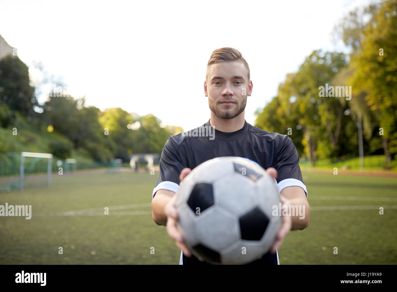 Fußballspieler mit Ball auf Fußballplatz Stockfoto