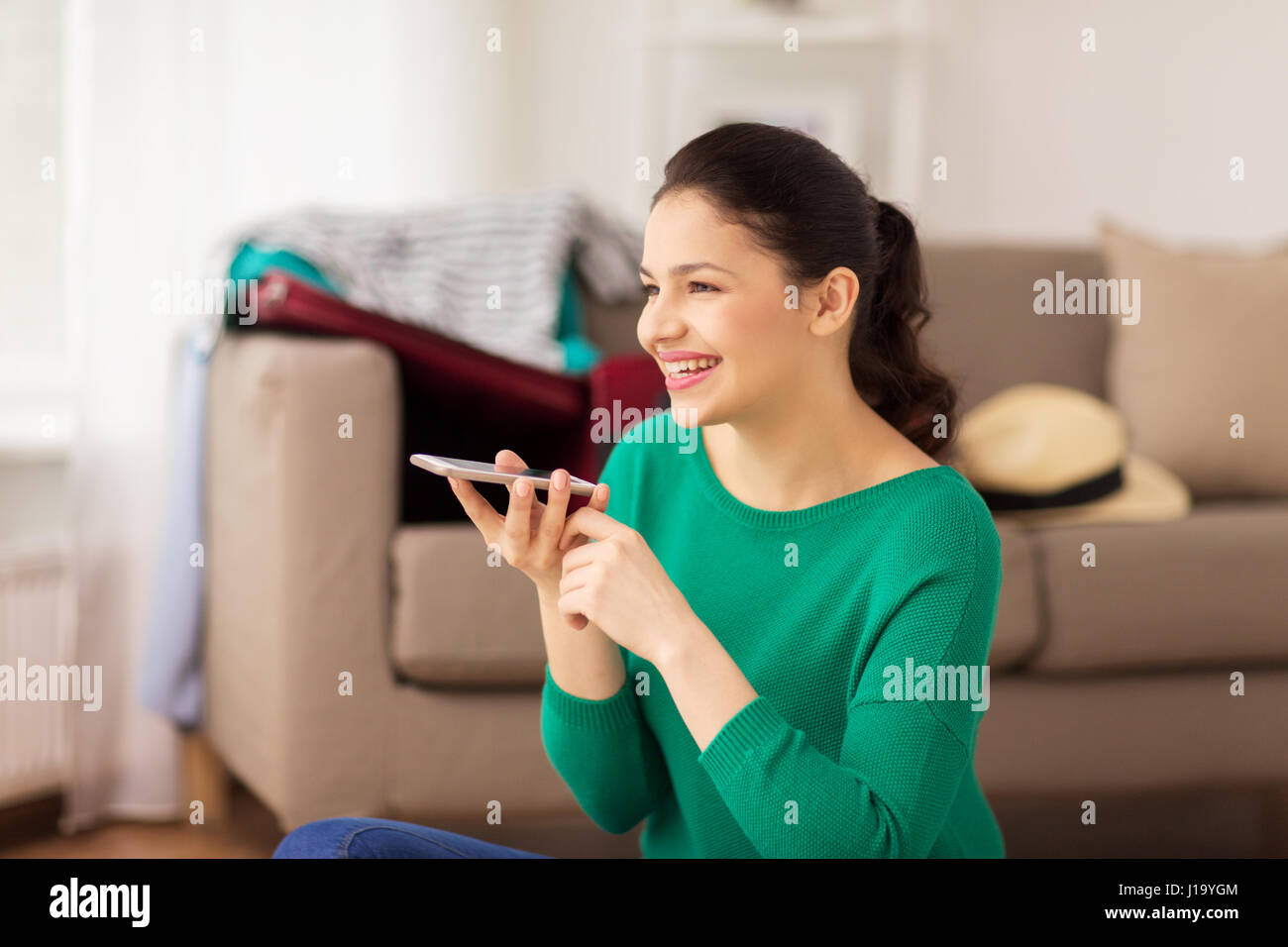 Frau mit Smartphone und Reise-Karte zu Hause Stockfoto