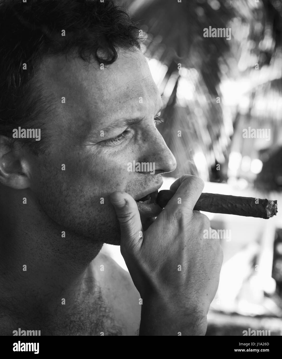 Junge europäische Mann raucht dicke Zigarre, Nahaufnahme von schwarzen und weißen Gesicht Portrait mit selektiven Fokus. Dominikanische Republik Stockfoto