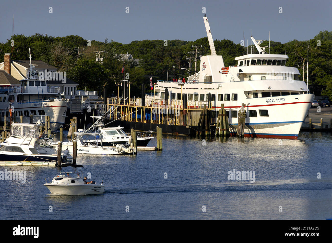 Ein kleines Boot übergibt die MV große Nummer und Grande Punto am Hyline Dock vor ihrer ersten Fahrten des Tages.  Hyannis Harbor, Mass - USA Stockfoto