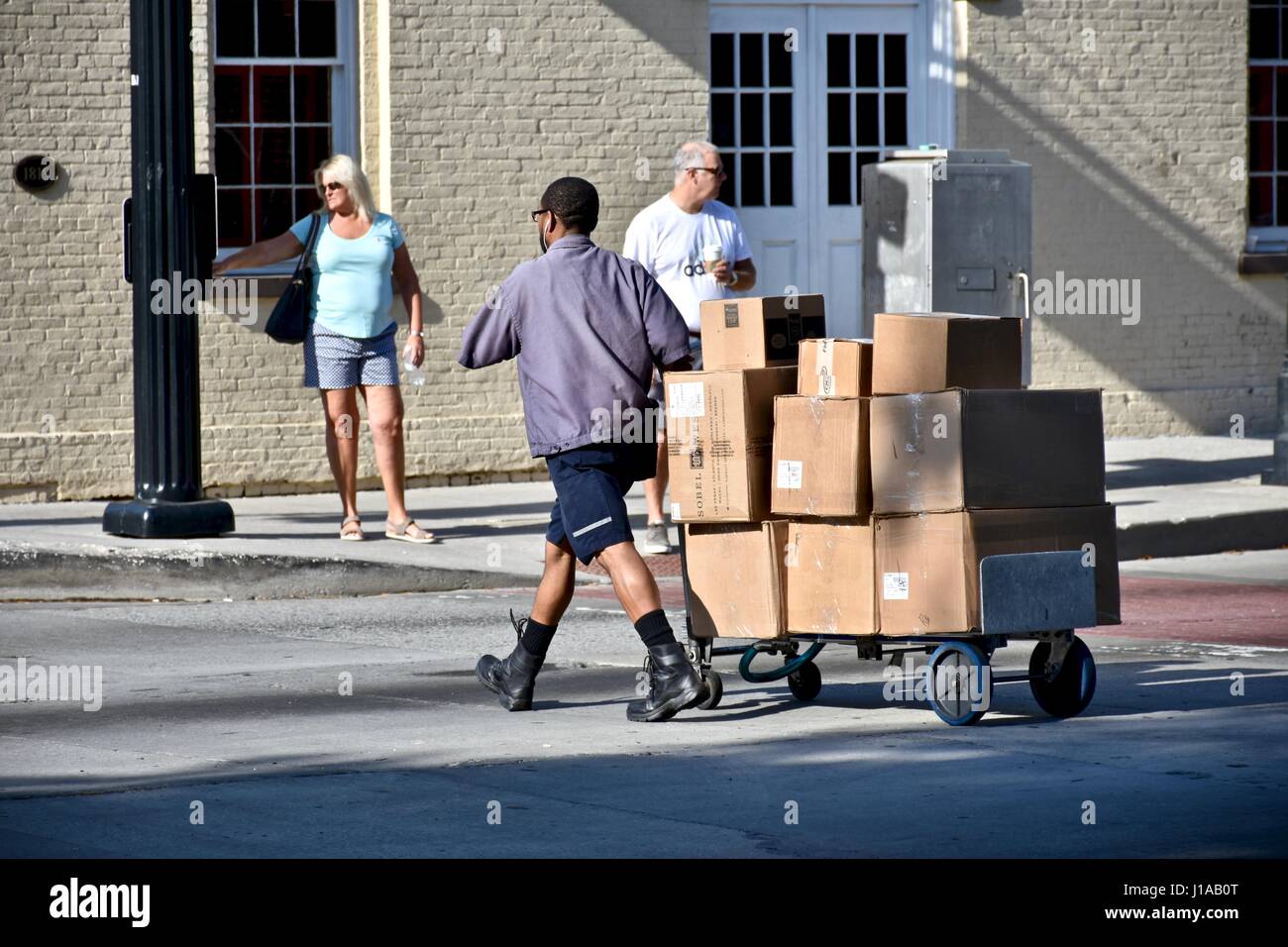 Briefzusteller Boxen durch die Stadt ziehen Stockfoto