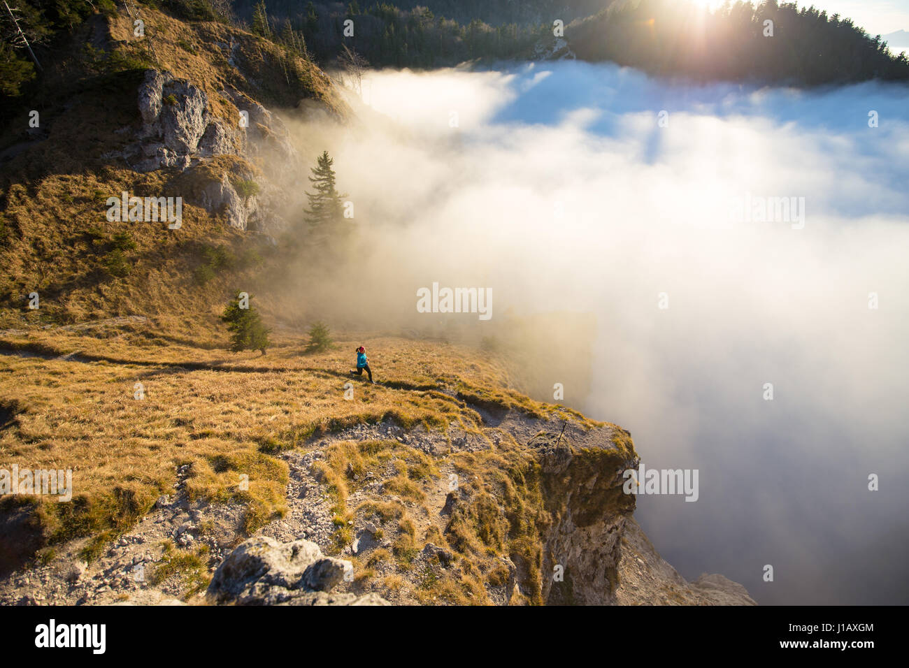 Eine junge Frau tut Berglauf oder eine Trail-Lauf am schönen Nockstein Berg in Salzburg, Österreich. Stockfoto