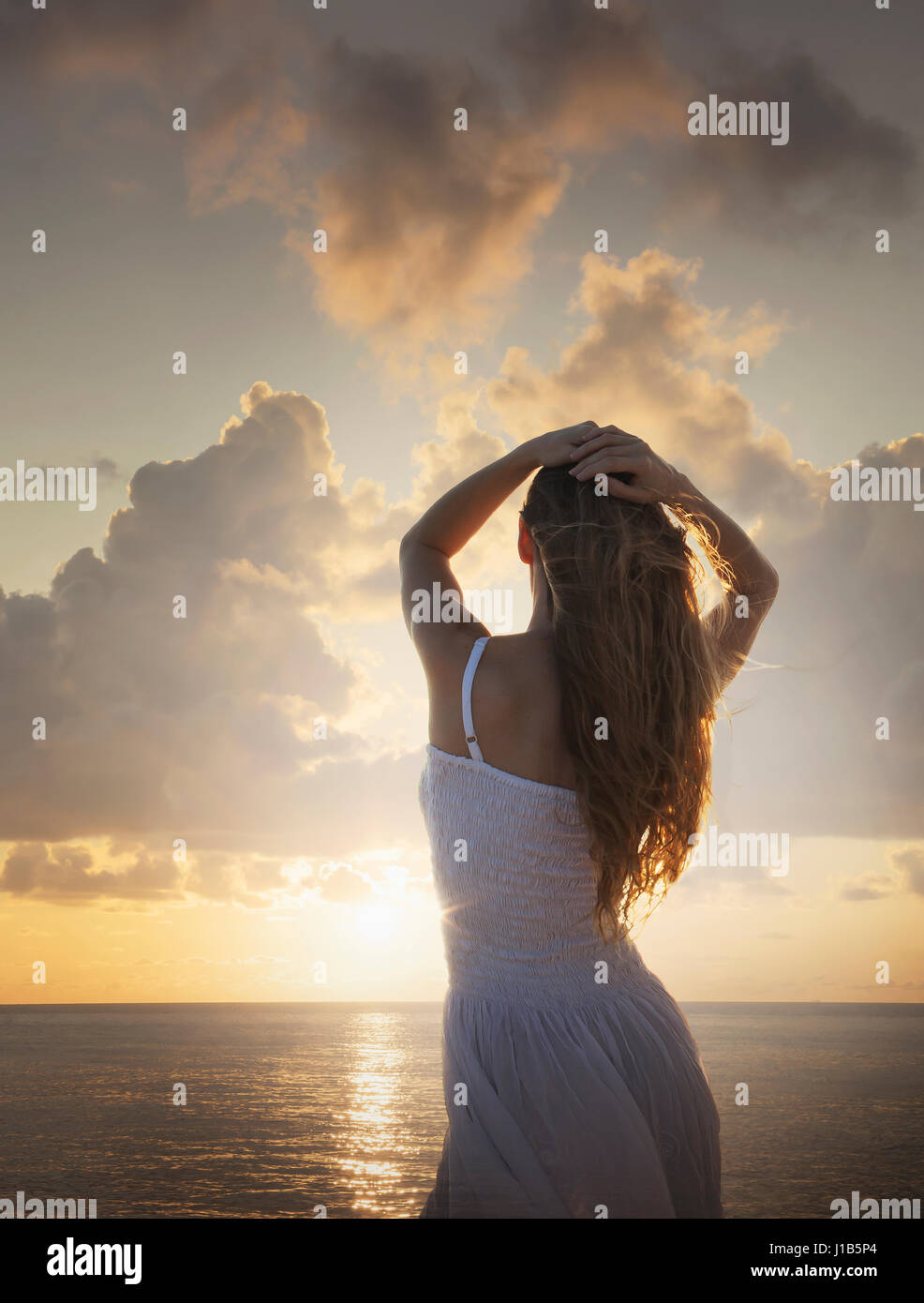 Kaukasische Frau Sonnenuntergang am Meer bewundern Stockfoto