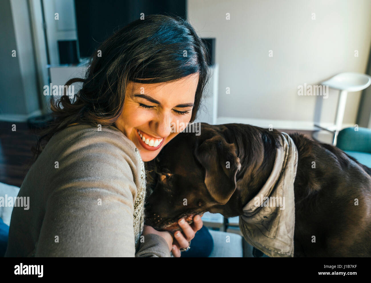 Gemischte Rennen Frau umarmt Hund Stockfoto
