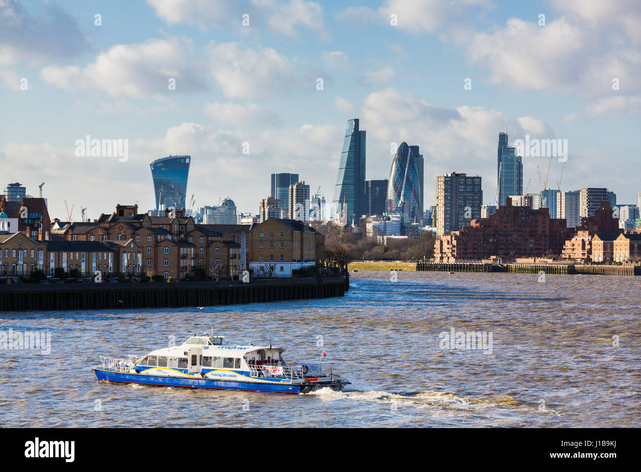 Der Londoner City Skyline mit Thames Clipper Fähre von Canary Wharf, Docklands, London, Großbritannien Stockfoto