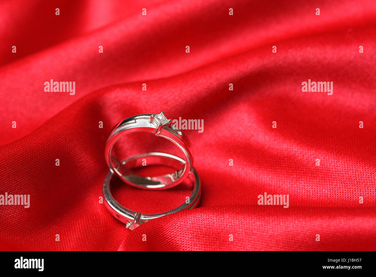 Ein paar Trauringe auf einem roten Tuch Stockfoto