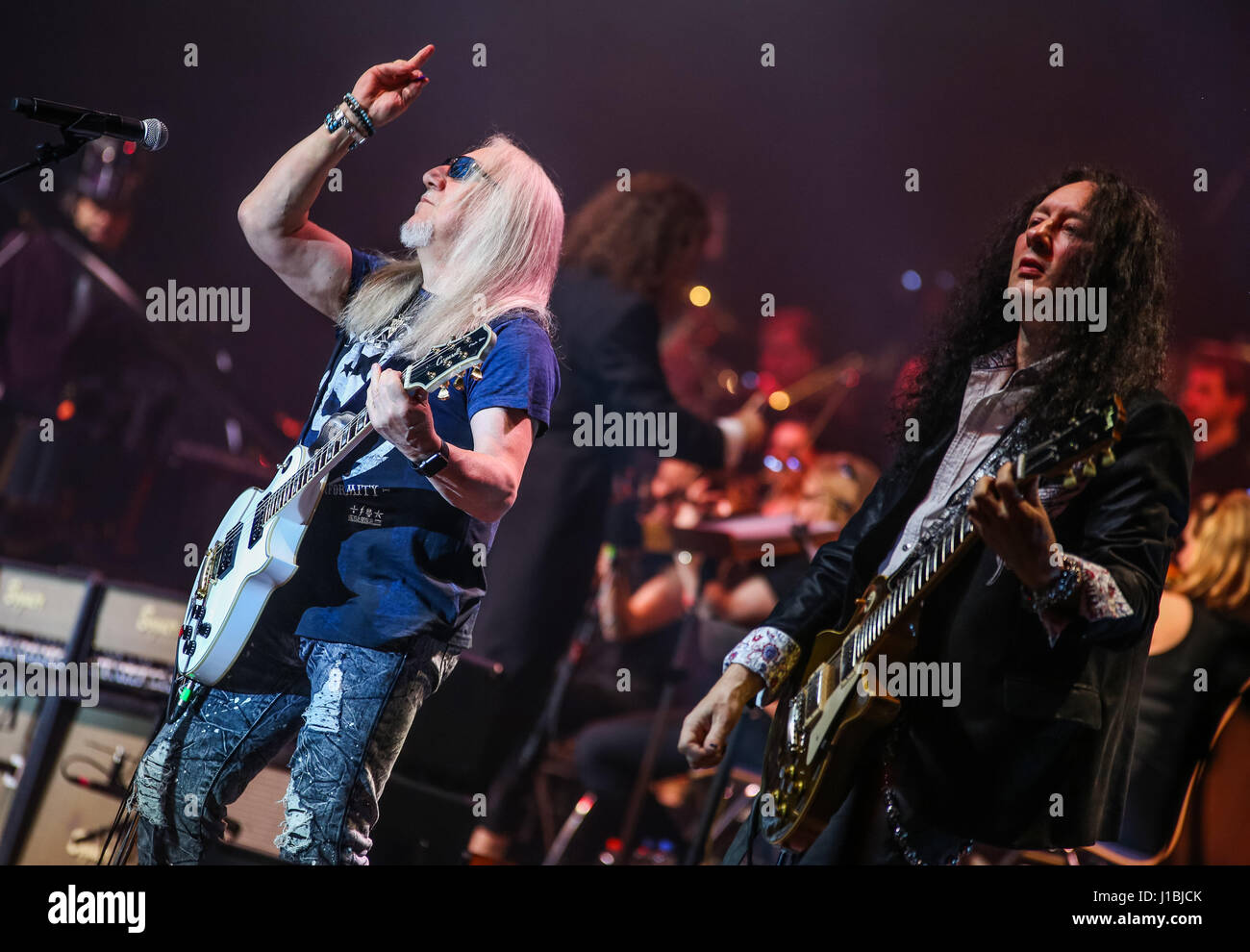 Wetzlar, Deutschland, 13. April 2017. Mick Box (Mitte), Gitarrist der britischen Hardrock-Band Uriah Heep, (hier mit Gitarrist Alex Beyrodt/Mat Sinner Band, rechts) führt bei Rock Meets Classic 2017, Konzert-Show mit Rock-Legenden als Solisten, begleitet von Mat Sinner Band und Bohemian Symphony Orchestra Prag. Ort: Rittal-Arena, Wetzlar, Deutschland. Fotocredit: Christian Lademann Stockfoto