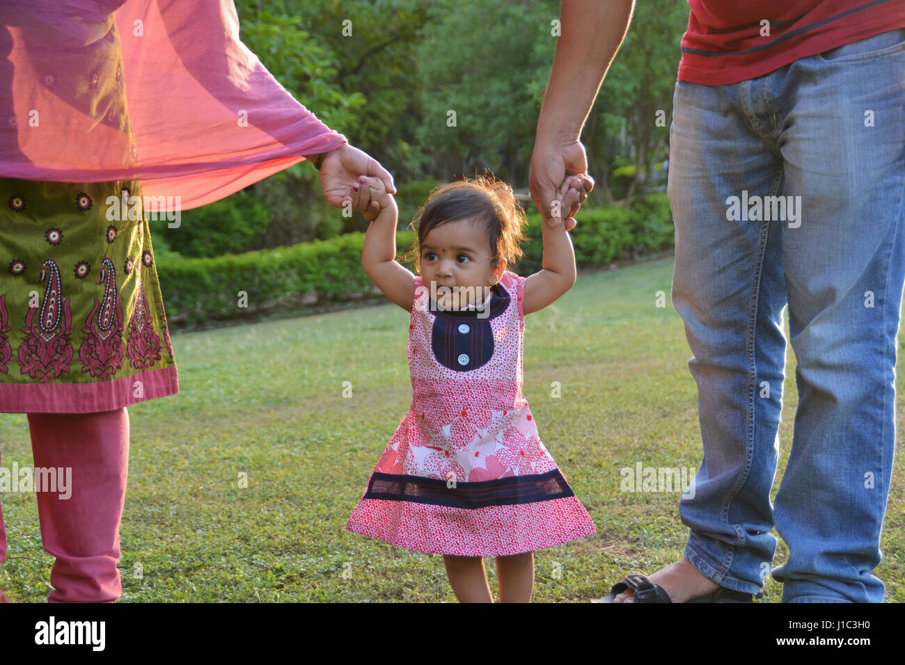 Babymädchen versuchen, halten Eltern gehen die Hände, Pune, Maharashtra. Stockfoto
