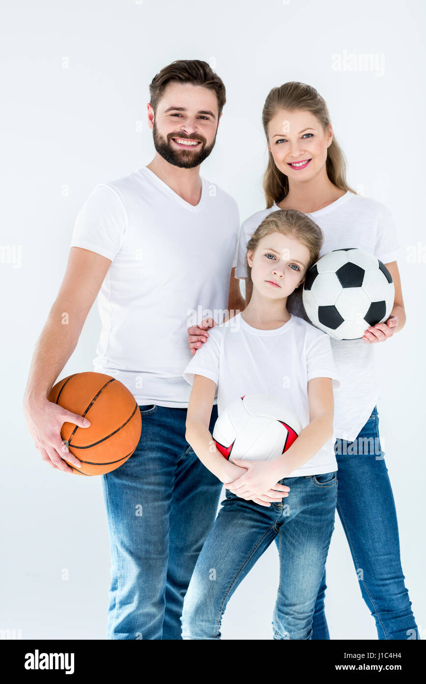 Porträt der jungen Familie mit verschiedenen Sportbälle auf weiß Stockfoto