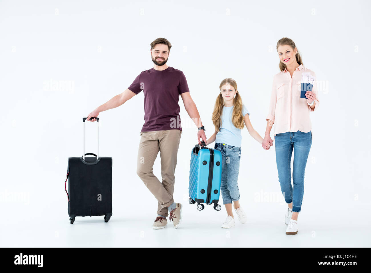 junge Familie mit Pässe, Tickets und Reisetaschen auf weiß Stockfoto