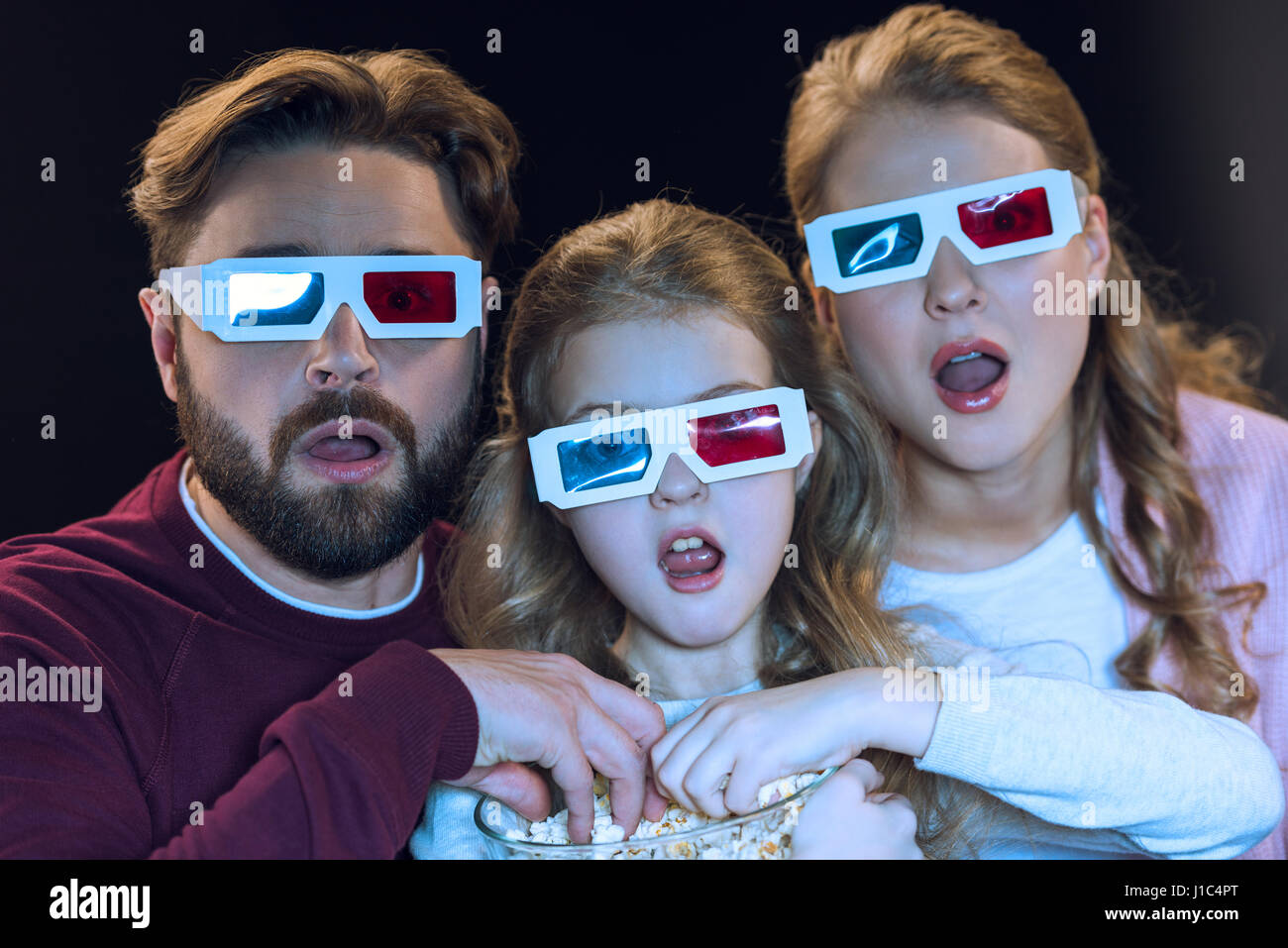 Schockiert Familie in 3d Brille Film und Essen Popcorn aus Schüssel Stockfoto