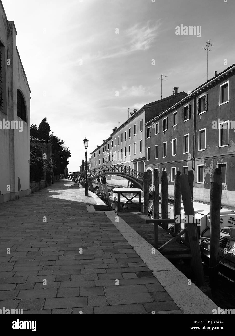 Kanal-Weg mit Pflaster Laternenpfahl und Boote in Guidecca in Venedig Stockfoto